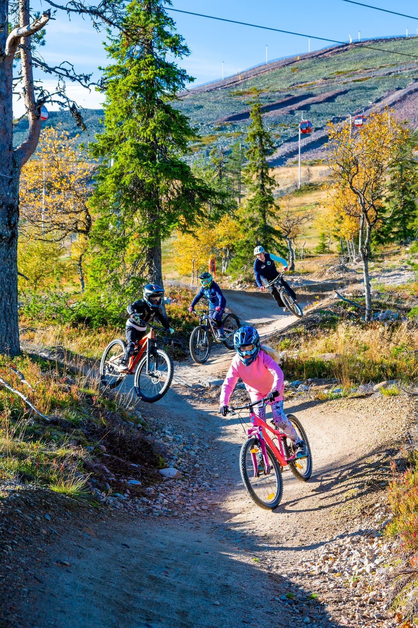 Lapsi hyppää pienen hypyn Pyörä-Werneri 2 -lasten kurssilla Ylläs Bike Parkissa