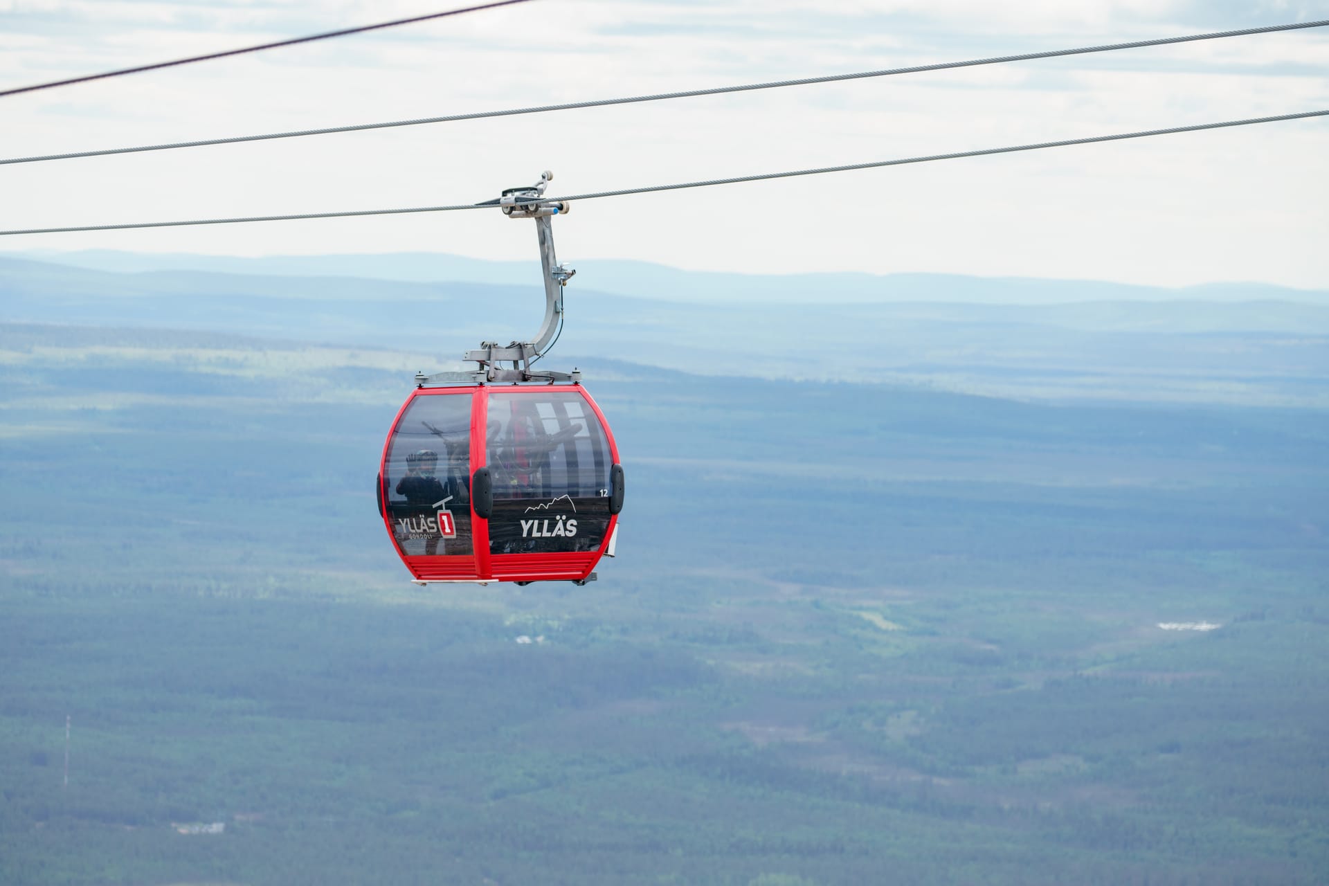 Ylläksen gondolivaunu hissikannattimella, taustalla tunturi ja metsä.