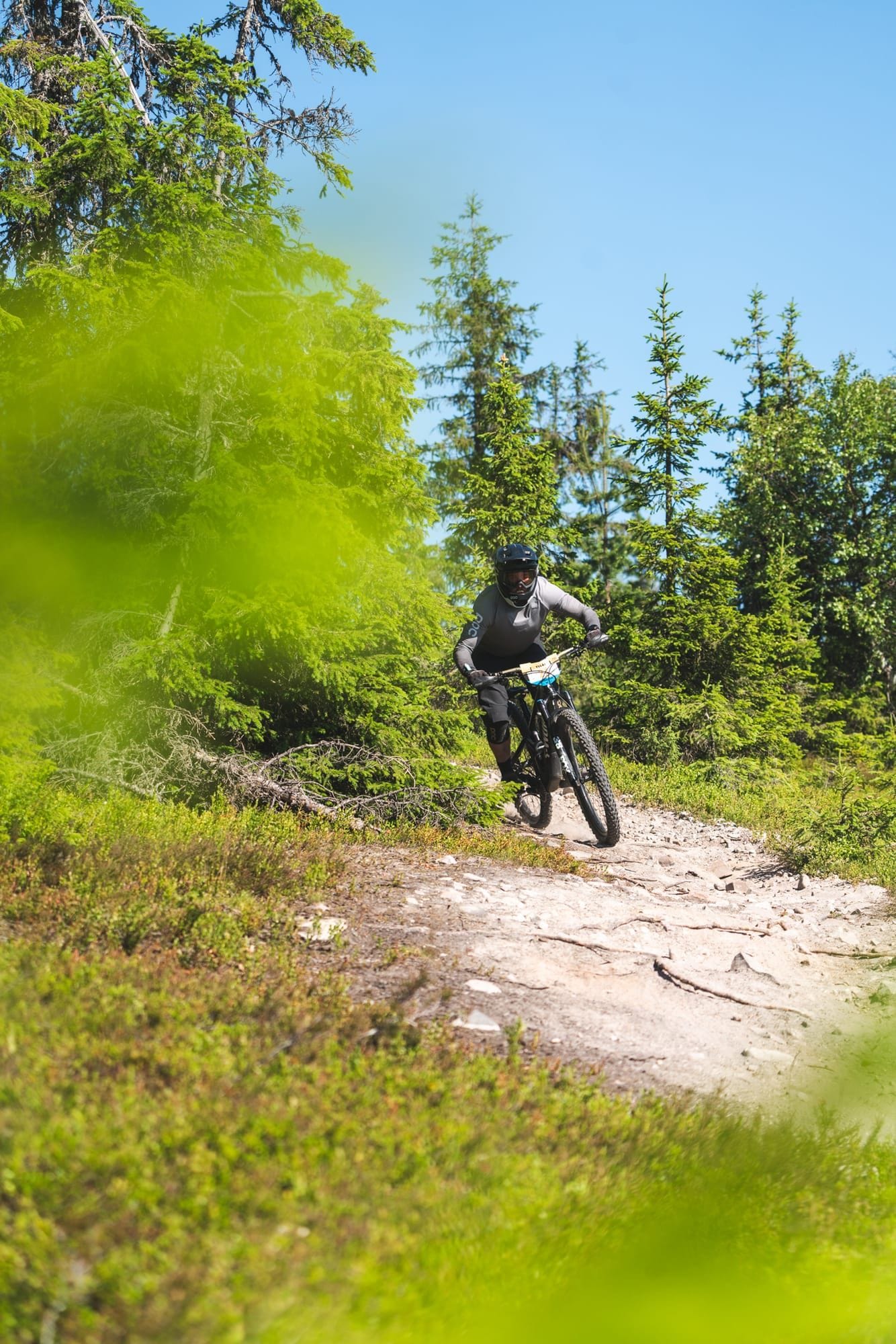 Rider navigating rocks and roots on the Enduro Twist trail at Ylläs Bike Park