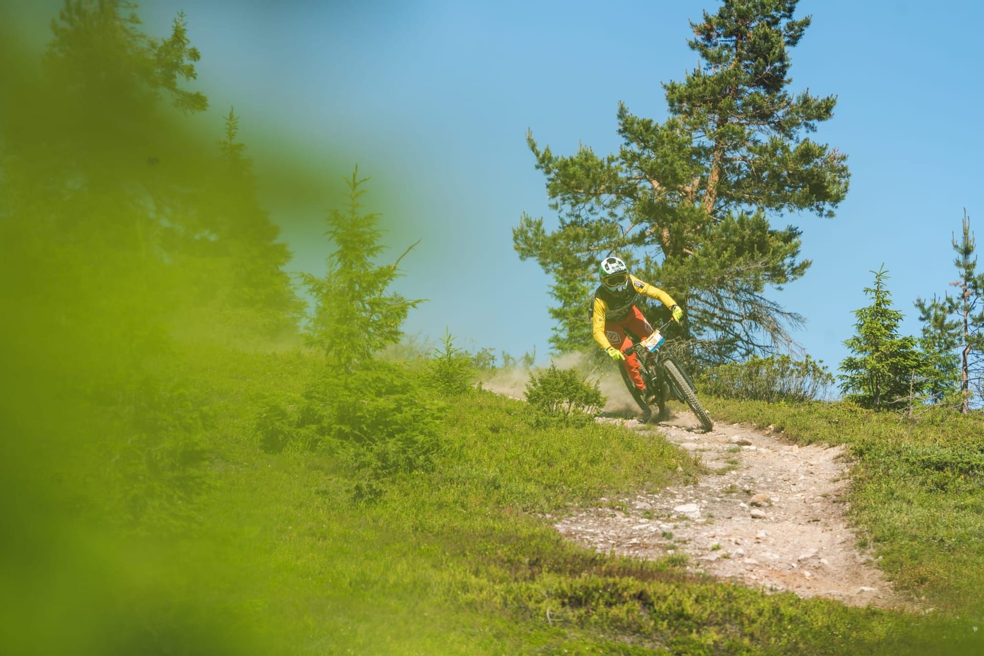 Rider navigating rocks and roots on the Enduro Twist trail at Ylläs Bike Park