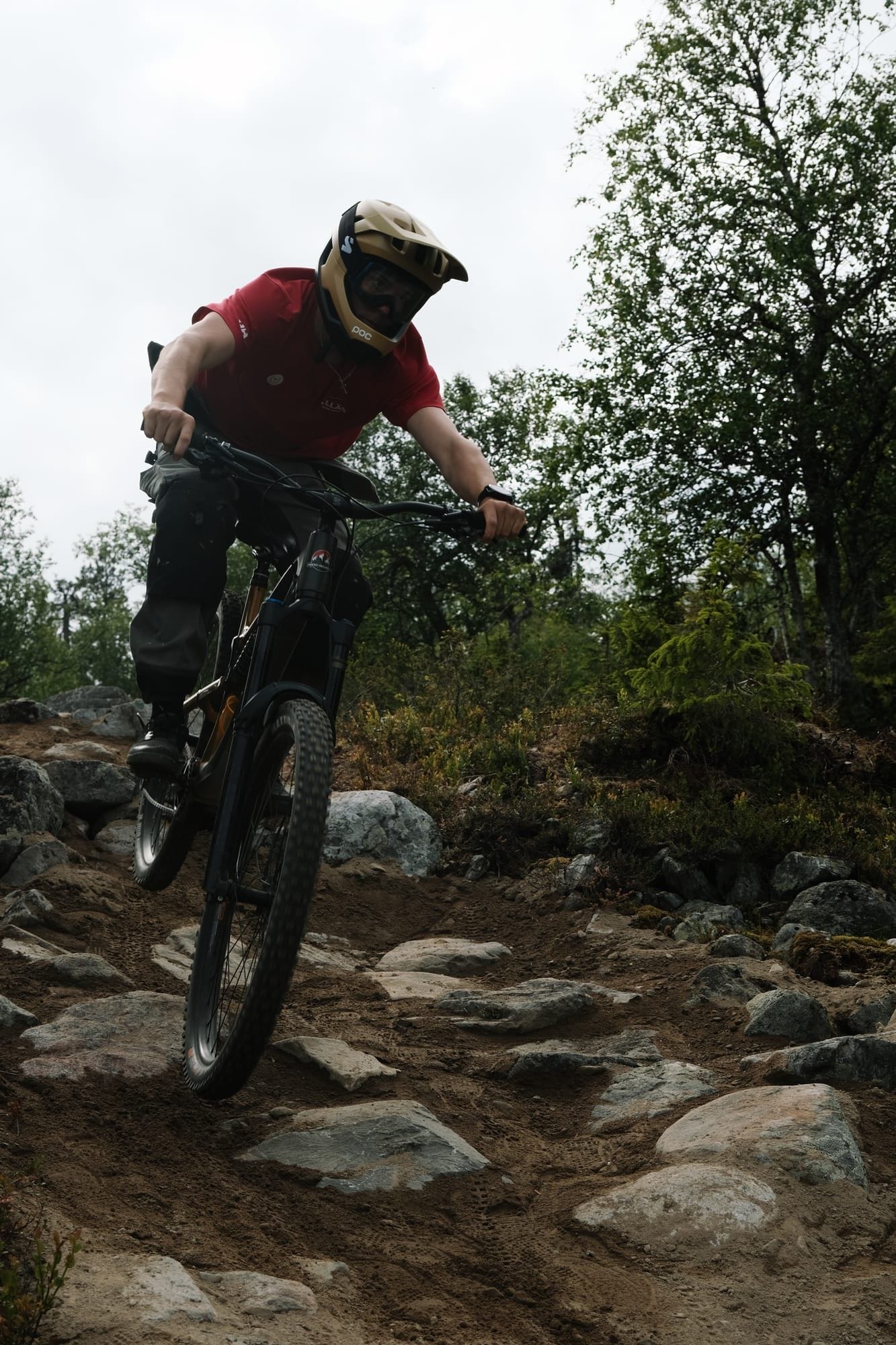 Biker riding a rock drop on the Mr. Hankey black trail at Ylläs Bike Park